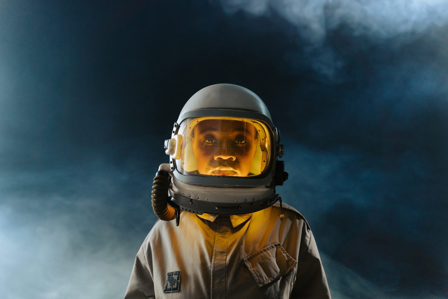 Man in White Helmet with Orange Light and Brown Space Suit  in Outerspace